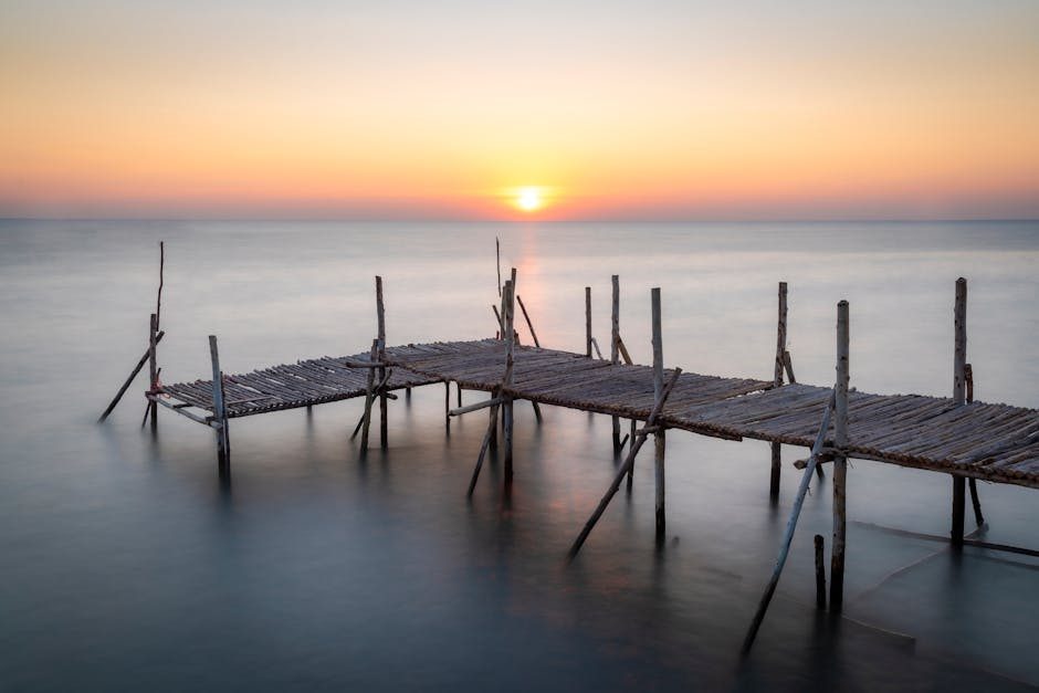 Captivating sunset over a wooden pier on a tranquil Thai seascape, offering a peaceful retreat.