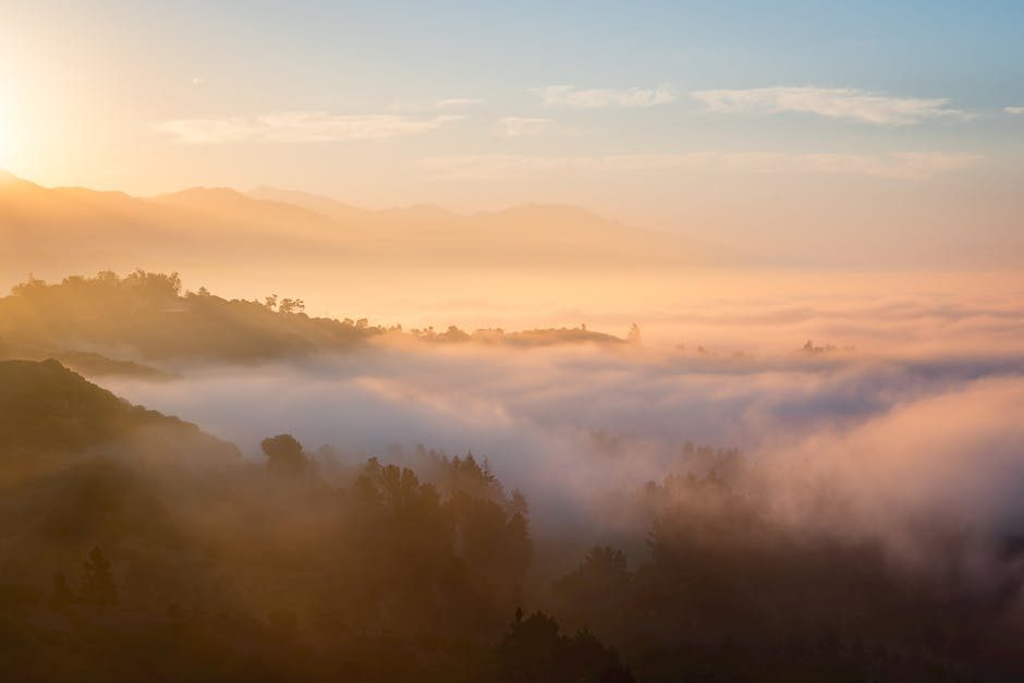 Captivating sunrise over mountain range with clouds, creating a serene landscape perfect for nature enthusiasts.